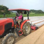 赤いトラクターに乗る農業女子